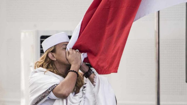 Bahar bin Smith mencium bendera merah putih seusai menjalani sidang putusan di gedung Arsip dan Perpustakaan. Foto: ANTARA FOTO/M Agung Rajasa