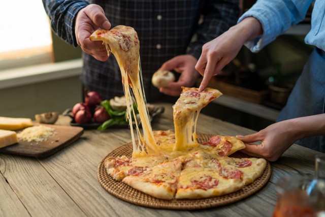 ilustrasi pasangan menikmati pizza keju. Foto: Shutterstock