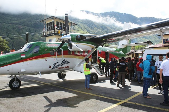 Saat jenazah pemuda yang meninggal dunia di dalam pesawat karena sakit tiba di Bandara Mulia, Puncak Jaya. (Foto dok Humas Polda Papua)