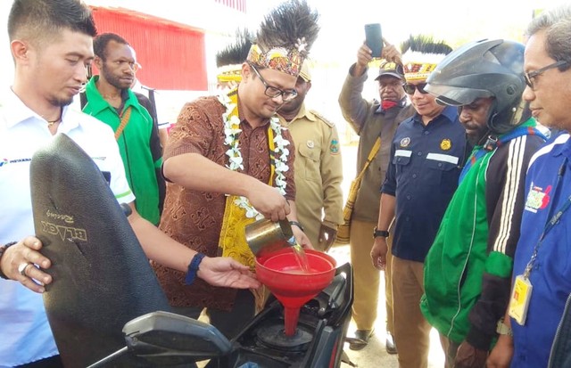 Pengisian BBM pertama pada sebuah motor saat peresmian BBM Satu Harga di SPBU Kompak Eguwai Diti di Distrik Mapia, Dogiyai, Papua. (Foto Katharina)