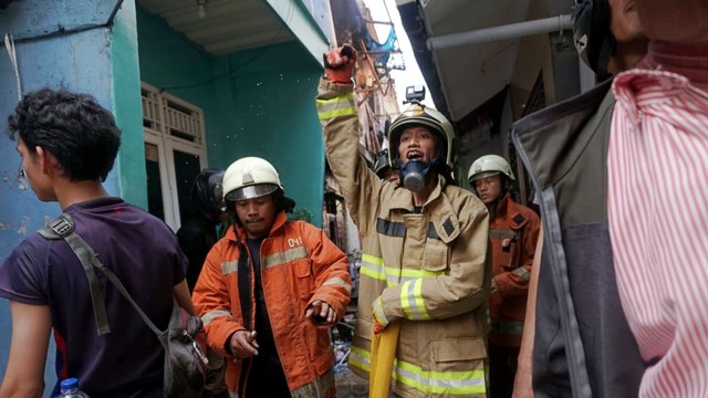 Petugas memadamkan kebakaran di Kampung Bali Manggarai. Foto: Iqbal Firdaus/kumparan
