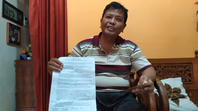 Ketua RW 02 Kelurahan Mulyorejo, Ashari, menunjukkan surat edaran yang dibuatnya. (Foto: Gigih Mazda/Tugu Malang).