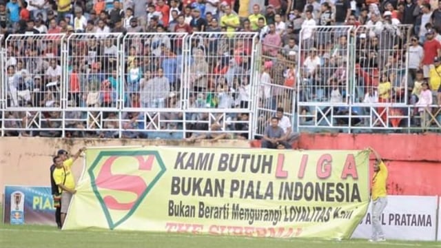 Sebuah spanduk bertulisakan "Kami Butuh Liga Bukan Piala Indonesia" di lapangan Gelira Kieraha. Sumber Foto: Fb Asghar Saleh.