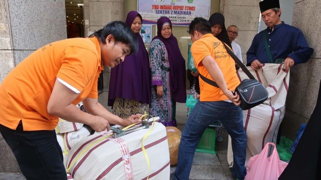 Petugas mengepak barang belanjaan jemaah haji untuk dikirim ke Indonesia di Madinah, Sabtu (13/7). Foto: Darmawan/Media Center Haji