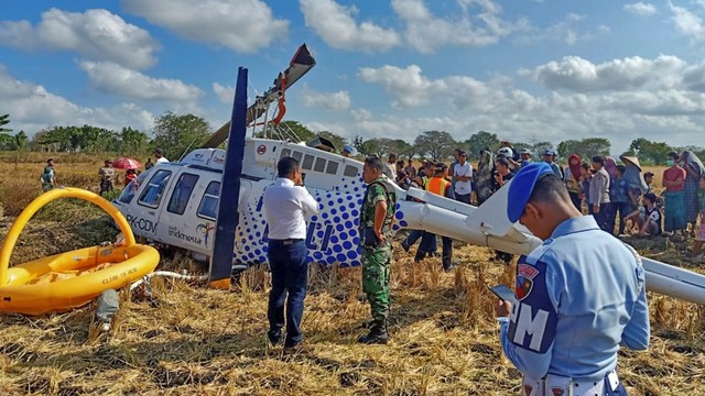 Sejumlah petugas berada di dekat pesawat helikopter B206L4 PKCDV milik PT. Carpediem Air rute Labuan Bajo-Lombok yang jatuh di luar pagar Bandara Internasional Lombok. Foto: ANTARA FOTO/Basarnas NTB