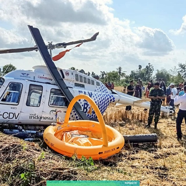 Sejumlah petugas berada di dekat pesawat helikopter B206L4 PKCDV milik PT. Carpediem Air rute Labuan Bajo-Lombok yang jatuh di luar pagar Bandara Internasional Lombok. Foto: ANTARA FOTO/Basarnas NTB