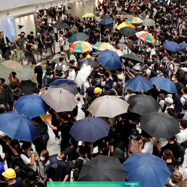 Demonstran pro demokrasi memegang payung di dalam Mal saat berhadapan dengan polisi anti huru hara di Distrik Sha Tin, Hong Kong. Foto: Reuters/Tyrone Siu