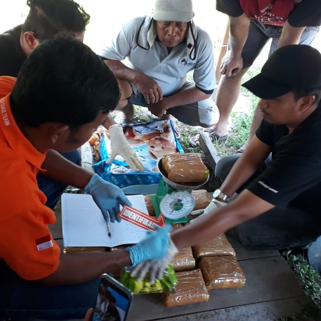 SATRES Narkoba Polres Bengkalis saat melakukan identifikasi penemuan 16 bungku sabu-sabu dengan berat sekitar 18,8 kg dibungkus plastik dibuang ke pinggir jalan Desa Kelapapati Darat, Bengkalis, Riau, Sabtu pagi, 13 Juli 2019 