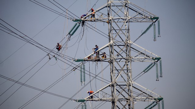 Pekerja memasang instalasi listrik di menara Saluran Udara Tegangan Ekstra Tinggi (SUTET) di arteri Porong, Sidoarjo, Jawa Timur, Senin (15/7/2019). Foto: Antara Foto/Umarul Faruq