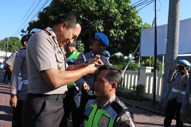 Kapolres Majalengka AKBP Mariyono menggunting rambut anggota Polres Majalengka yang kedapatan tidak sesuai aturan. (Oki)