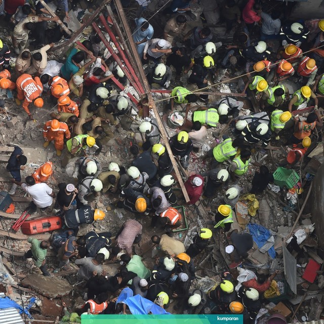 Petugas pemadam kebakaran India dan petugas penyelamat mencari korban bangunan runtuh di Mumbai, Selasa (16/7). Foto: AFP/PUNIT PARANJPE
