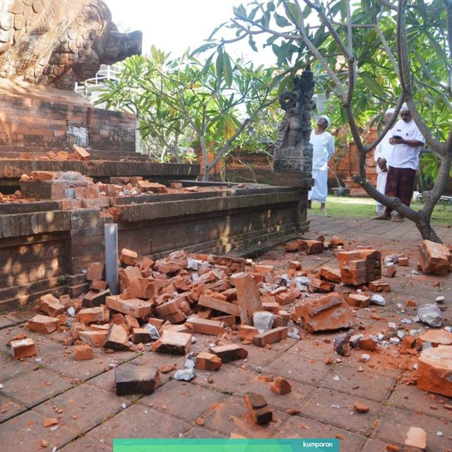 Pemuka agama Hindu memantau kerusakan pada bagian candi yang runtuh akibat gempa di Pura Lokanatha, Denpasar, Bali, Selasa (16/7/2019). Foto: ANTARA FOTO/Nyoman Budhiana
