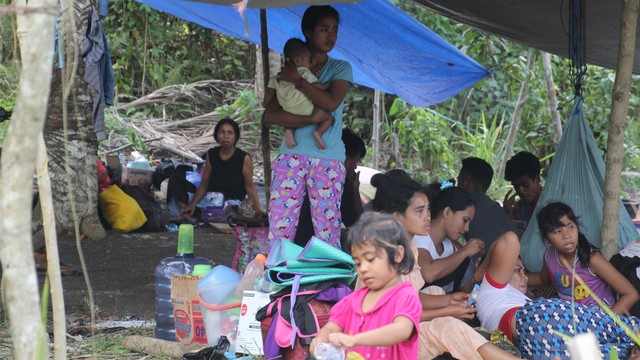 Seorang ibu menggendong bayi di tenda pengungsian, Bacan, Halmahera Selatan. Beberapa anak-anak terlihat berkumpul dan tidur beralaskan tikar seadanya, Selasa 16 Juli 2019. Foto: Faris Bobero/cermat