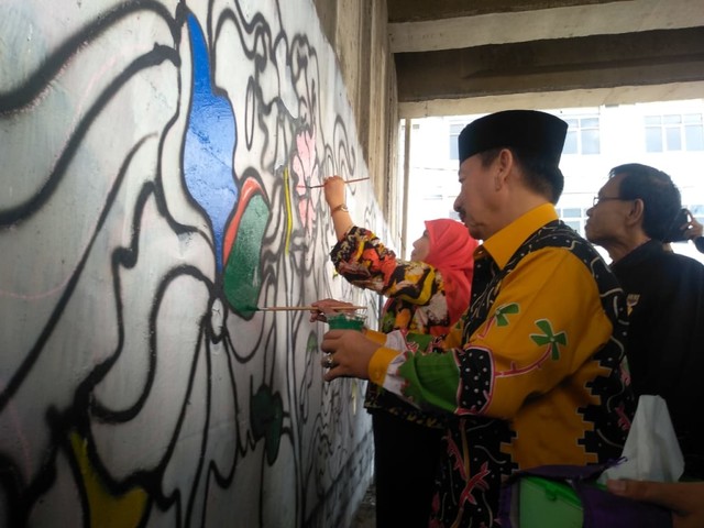 Walikota Herman HN serta Eva Dwiana Herman HN saat sedang melukis dinding flyover, Kamis (18/7) | Foto :  Rafika Restiningtias/ Lampung Geh