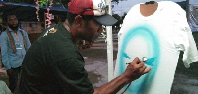 Salah satu putra Moi memamerkan keahliannya menggambar diatas baju. Foto: Ana/Balleo News