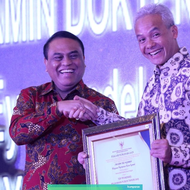 Gubernur Jawa Tengah Ganjar Pranowo (kanan) saat menerima penghargaan dari Menpan RB Syafruddin. Foto: Afiati Tsalitsati/kumparan