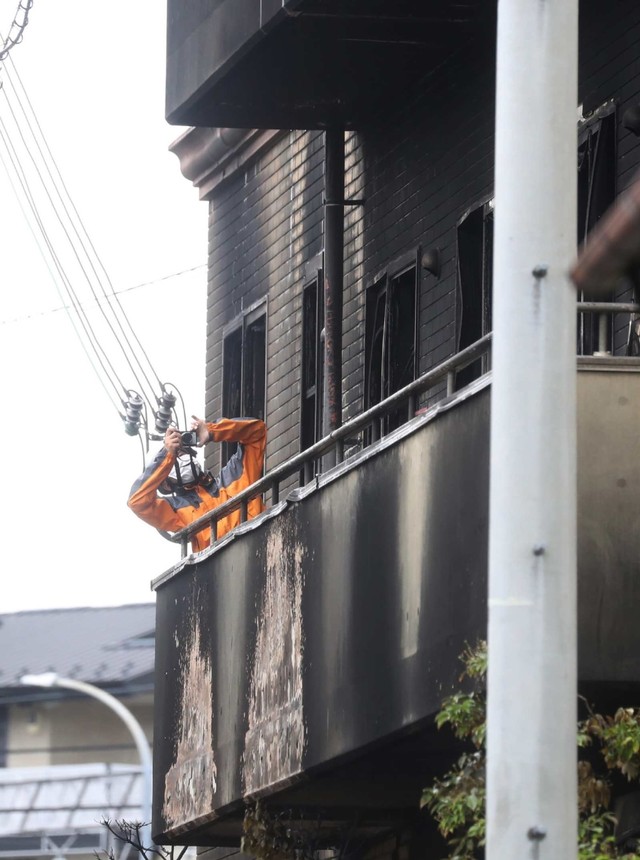 Seorang petugas pemadam kebakaran melihat gedung Animasi Kyoto yang dibakar di Kyoto, Jepang. Foto: AFP/ JAPAN POOL VIA JIJI PRESS