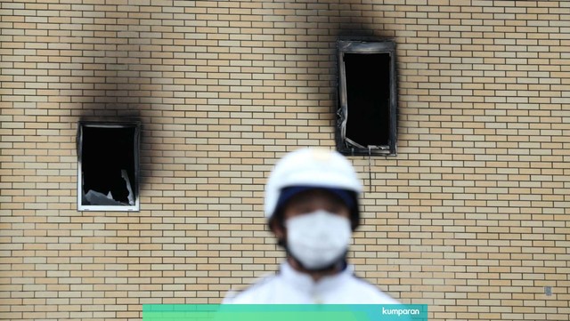 Seorang petugas kepolisian berada di dekat gedung Animasi Kyoto yang dibakar di Kyoto, Jepang. Foto: AFP/Buddhika Weerasinghe