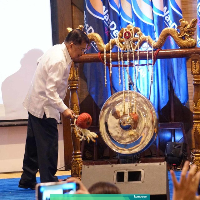 Wakil Presiden Jusuf Kalla memukul gong pada saat acara penutupan sekolah legislatif Partai NasDem di Auditorium Bela Negara Partai NasDem, Pancoran, Jakarta, Jumat (19/7). Foto: Jamal Ramadhan/kumparan