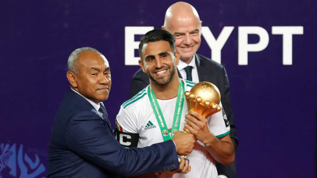 Riyad Mahrez (tengah) memegang trofi usai menjuarai Piala Afrika 2019, Sabtu (20/9). Foto: AFP / Khaled DESOUKI