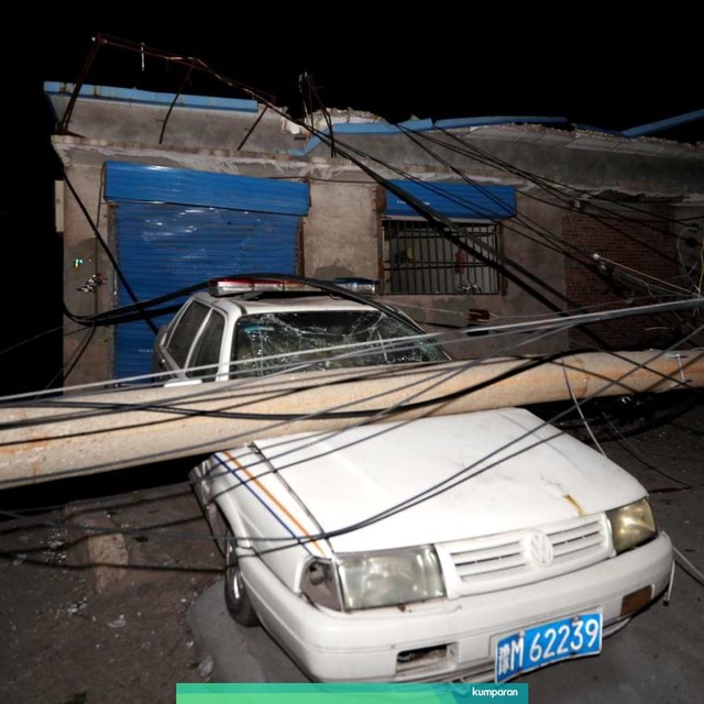Sebuah mobil tertimpa tiang di dekat lokasi ledakan pabrik Henan Coal Gas Group di kota Yima, China. Foto: AFP/STR