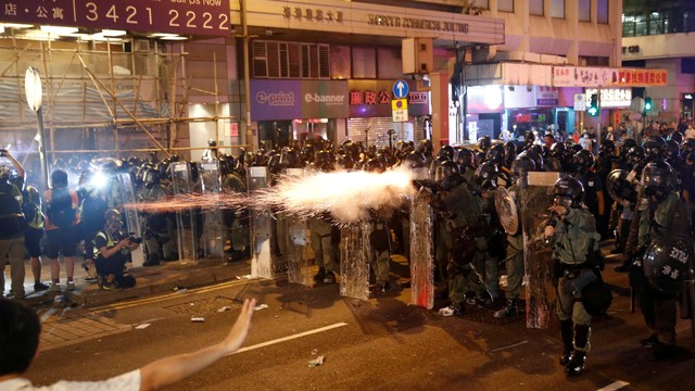 Polisi anti huru hara menembakkan gas air mata ke arah demonstran yang menolak RUU ekstradisi di Hong Kong, China, Minggu (21/7). Foto: REUTERS/Edgar Su