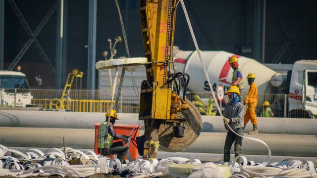 Pekerja menggunakan alat berat guna menyelesaikan konstruksi jalur kereta api pada proyek pembangunan Stasiun Kereta Cepat Jakarta-Bandung di Tegalluar, Kabupaten Bandung, Jawa Barat, Senin (22/7/2019). Foto: ANTARA FOTO/Raisan Al Farisi
