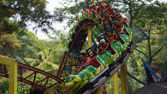 Sejumlah petugas Penanganan Prasarana Sarana Umum (PPSU) DKI Jakarta mencoba wahana permainan saat berwisata di Dufan, Ancol, Jakarta, Senin (22/7). Foto: ANTARA FOTO/Wahyu Putro A
