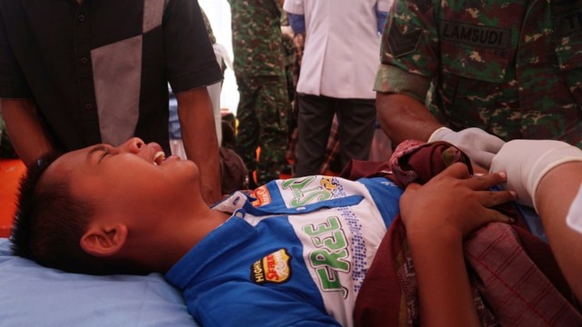 Seorang anak menangis saat ikuti khitanan massal di Lapangan Merdeka, Balikpapan. Foto: Fanny Kusumawardhani/kumparan