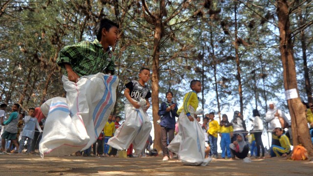 Sejumlah anak mengikuti lomba balap karung, di Pantai Ujung Batu, Padang, Sumatera Barat. Foto: ANTARA FOTO/Iggoy el Fitra