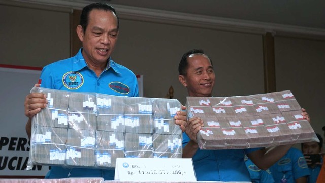 Deputi Bidang Pemberantasan BNN Irjen Pol Arman Depari (kiri) menunjukkan barang bukti uang tindak pidana pencucian uang (TPPU) di Kantor BNN, Cawang, Jakarta Timur. Foto: Iqbal Firdaus/kumparan