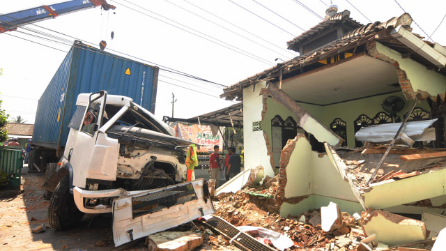 Warga berada di dekat reruntuhan bangunan yang ditabrak truk kontainer di Puskesmas Mojosongo, Boyolali, Jawa Tengah, Kamis (25/7). Foto: ANTARA FOTO/Aloysius Jarot Nugroho