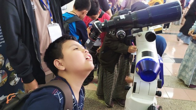 Salah seorang anak mencoba teleskop di Festival Anak Bertanya (FAB) yang digelar di Sasana Budaya Ganesha (Sabuga), Bandung, Minggu (28/7). Foto: Rachmadi Rasyad/kumparan
