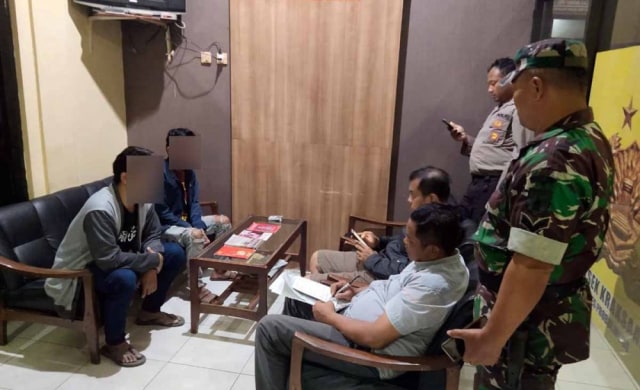 Dua mahasiswa (kiri) diinterogasi setelah kedapatan membuka lapak baca dan pinjam buku soal DN Aidit di Alun-Alun Kraksaan, Probolinggo. Foto: jatimnow.com