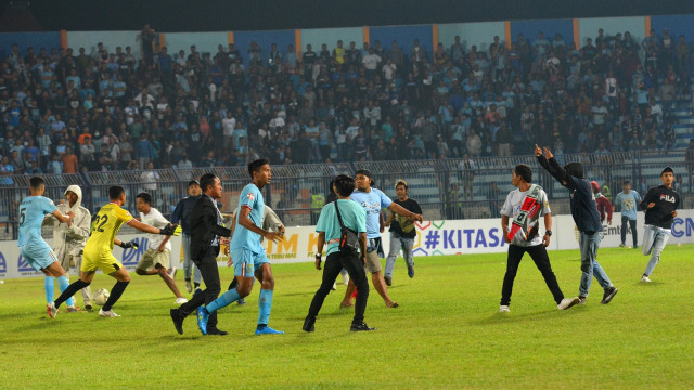 Suporter Persela masuk ke lapangan karena tak terima dengan keputusan wasit yang memberikan penalti untuk Borneo FC. Foto: Syaiful Arif/ANTARA