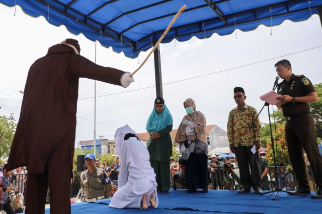 Algojo mencambuk seorang pelanggar syariat Islam di halaman Masjid Baitussalihin, Ulee Kareng, Kota Banda Aceh, Kamis (1/8). Foto: Suparta/acehkini. 