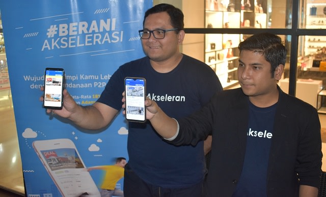 Rimba Laut, Senior Vice President Corporate Communication Akseleran dan Eben Napitupulu, Senior Vice President Retail Sales Akseleran menunjukan aplikasi Akseleran di handphone saat kegiatan Fintech Day di Kota Manado, Sulawesi Utara