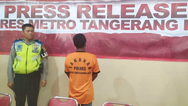 Anggota polisi Polres Metro Tangerang menunjukkan tersangka sopir truk yang menimpa mobil di Tangerang. Foto: Maulana Ramadhan/kumparan