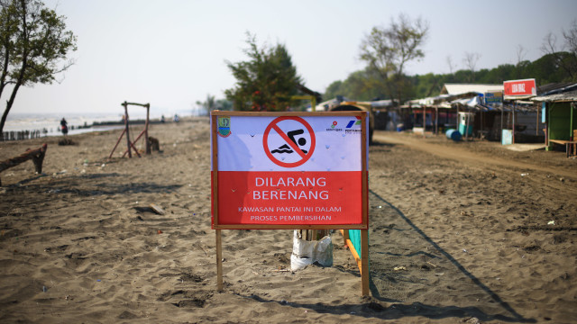 Tanda larangan berenang yang dipasang oleh pihak Pertamina akibat banyak tumpahan minyak (Oil Spill) di Pantai Sedari, Karawang, Jawa Barat, Kamis (1/8). Foto: Aditia Noviansyah/kumparan