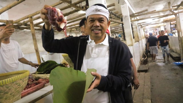 Mantan Bupati Purwakarta Dedi Mulyadi menunjukan cara membungkus daging kurban dengan memanfaatkan daun jati. Foto: Dok. Tim Media Dedi Mulyadi