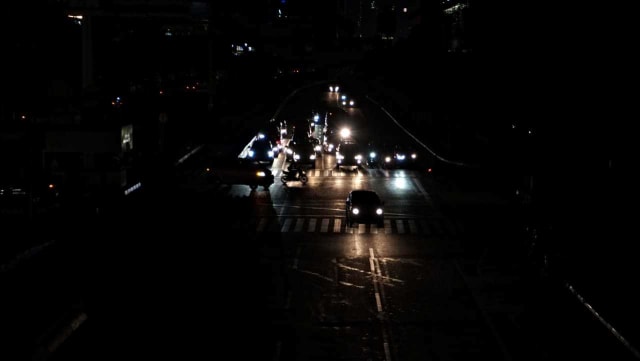 Sebuah kendaraan melintas di kawasan jalan Thamrin, Jakarta Pusat, yang terpantau gelap. Foto: Jamal Ramadhan/kumparan