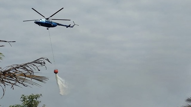 Helikopter water bombing membawa air untuk memadamkan lahan gambut yang terbakar. (Foto: Tim Satgas Karhutla Riau)
