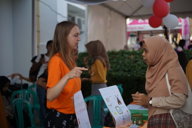 Mahasiswa asing saat berkomunikasi dengan pengunjung di Acara Global Village AIESEC Lampung, Minggu (4/8) | Foto : Dimas Prasetyo/Lampung Geh