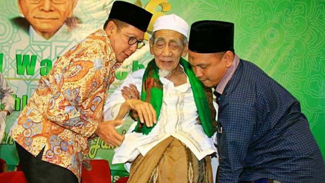 Menteri Agama Lukman Hakim Saifuddin (kiri) menggendong Mbah Moen. Foto: Faceboook/ @DPP PPP