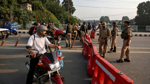 Personel keamanan India menghentikan orang selama pembatasan di Srinagar, India. Foto: REUTERS/Danish Ismail