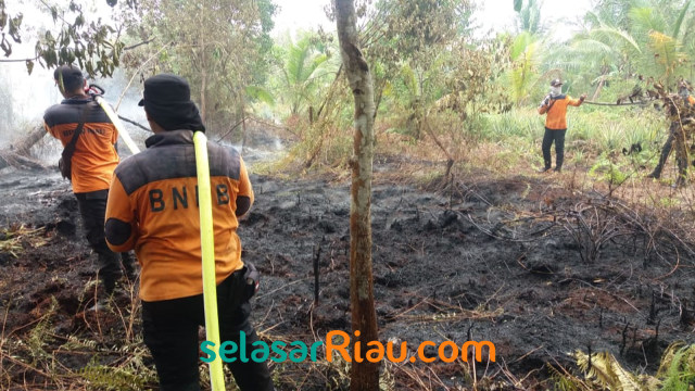 PETUGAS BNPB saat memadamkan api di Riau. 
