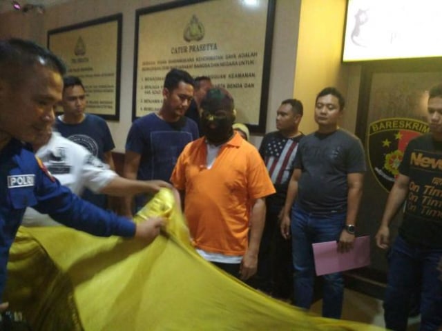Amat Tantoso menggunakan sebo saat di Polresta Barelang (Foto: Batamnews)
