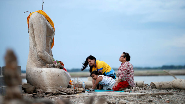 Warga beraktivitas di Kuil Buddha Thailand yang muncul kembali setelah terendam air selama 20 tahun. Foto: REUTERS/Soe Zeya Tun