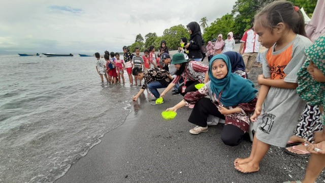 Pelepasan tukik atau anak penyu oleh mahasiswa KKN Kebangsaan bersama warga di Pantai Tobololo, Ternate. Foto: Istimewa