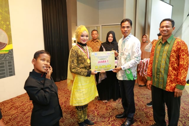 Kepala Dinas Pendidikan Aceh, Syaridin, menyerahkan penghargaan kepada juara I lomba pada ajang FLS2N Anak Berkebutuhan Khusus 2019 tingkat Provinsi Aceh. Foto: Dok. Disdik Aceh